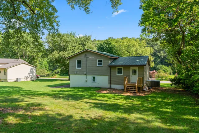 a front view of a house with a yard and trees