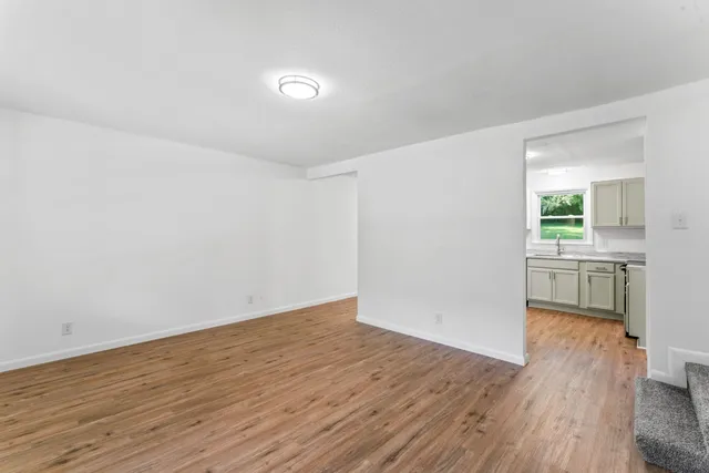 a view of a kitchen with wooden floor and a sink