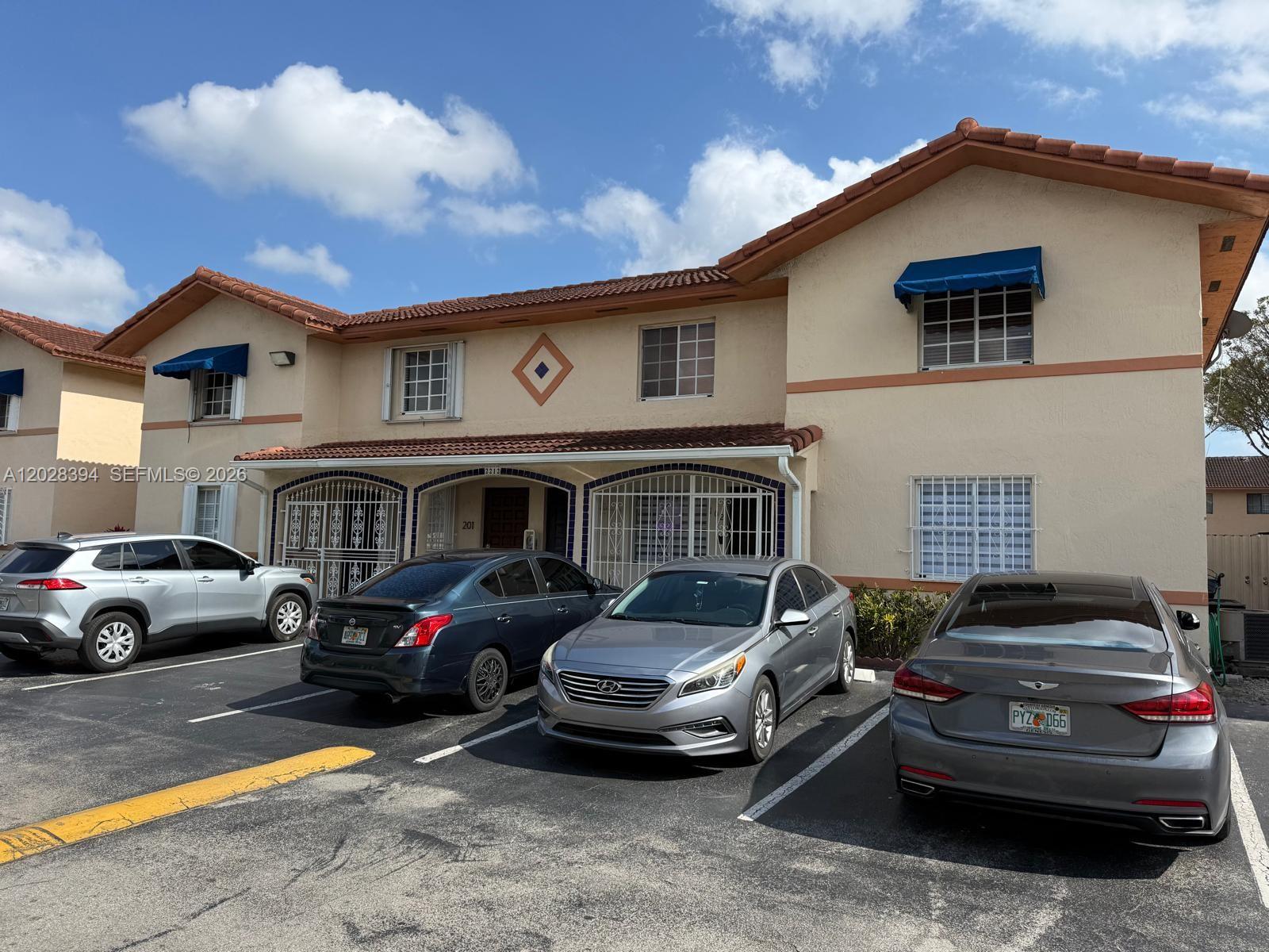 2212 West 74th Street, Unit 20128 Hialeah, FL 33016 - Photo 10 of 11 a front view of a house with parking