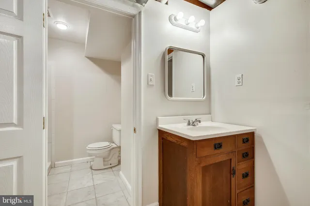 a bathroom with a toilet sink and mirror