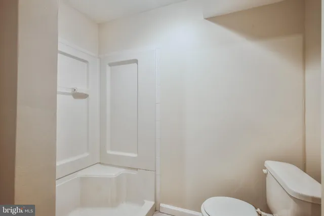 a white toilet sitting next to a bath tub