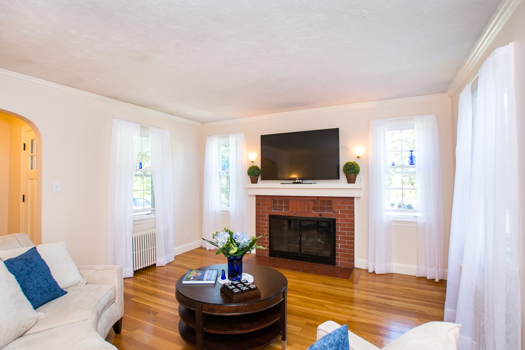 24 Murray Road Newton, MA 02465 - Photo 11 of 30 a living room with furniture a fireplace and a flat screen tv