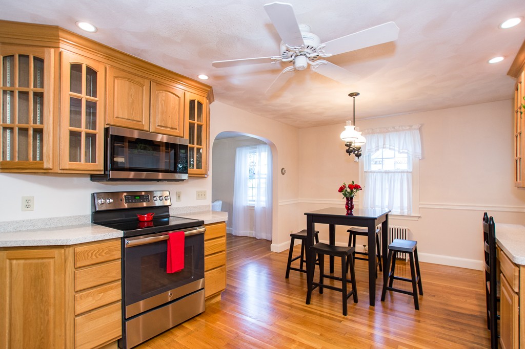 24 Murray Road Newton, MA 02465 - Photo 15 of 30 a kitchen with stainless steel appliances granite countertop a stove top oven a refrigerator a dining table and chairs with wooden floor