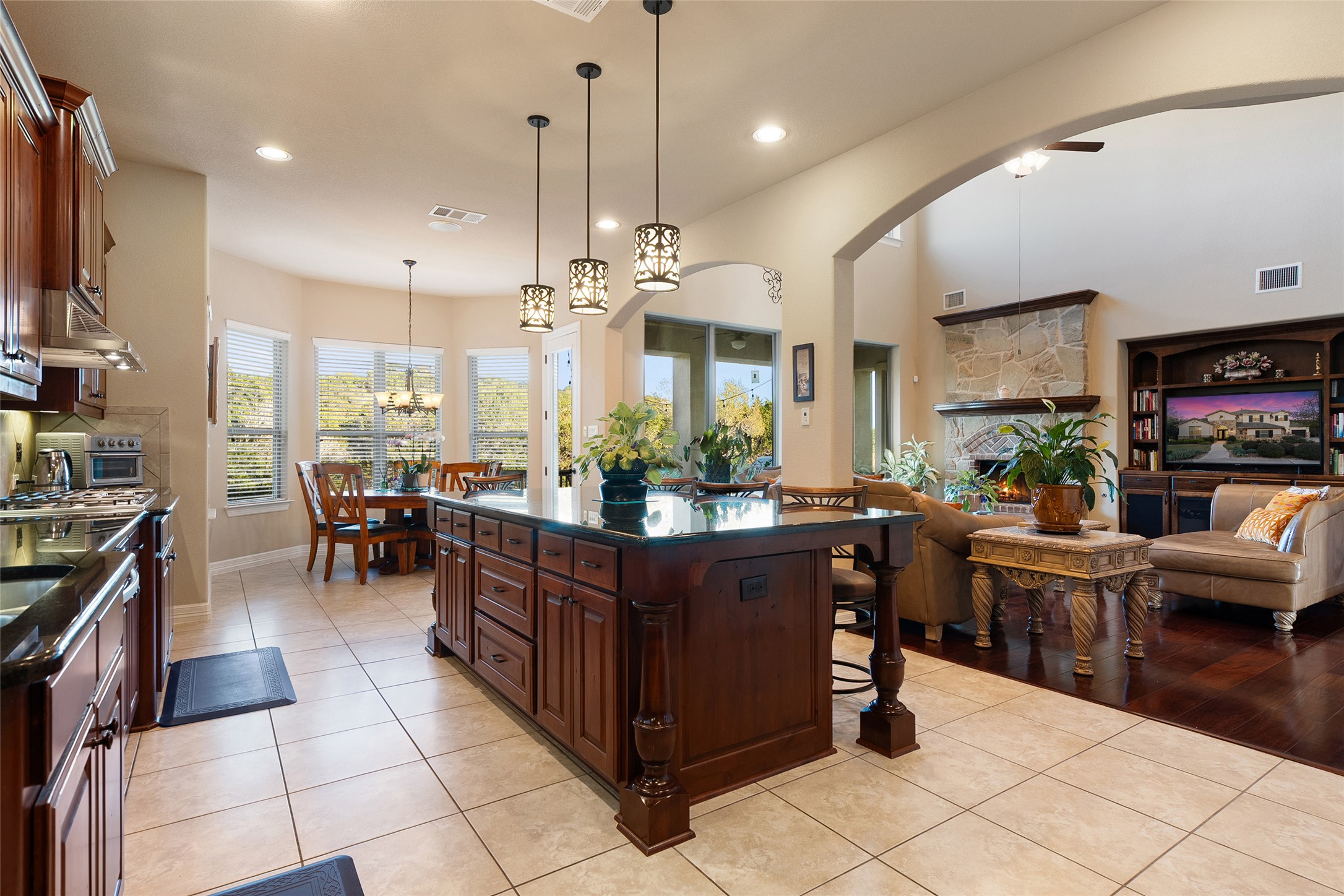 1200 Lions Lair Leander, TX 78641 - Photo 39 of 40 a kitchen with stainless steel appliances kitchen island granite countertop a table chairs and a refrigerator