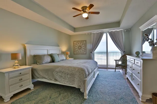 a bedroom with a large bed and a chandelier