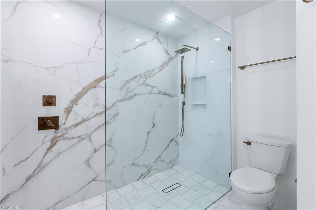 116 Fountain Circle Naples, FL 34119 - Photo 12 of 24 a bathroom with a toilet and a shower