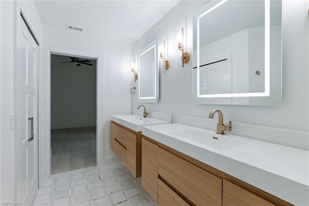 116 Fountain Circle Naples, FL 34119 - Photo 13 of 24 a bathroom with a sink and a mirror