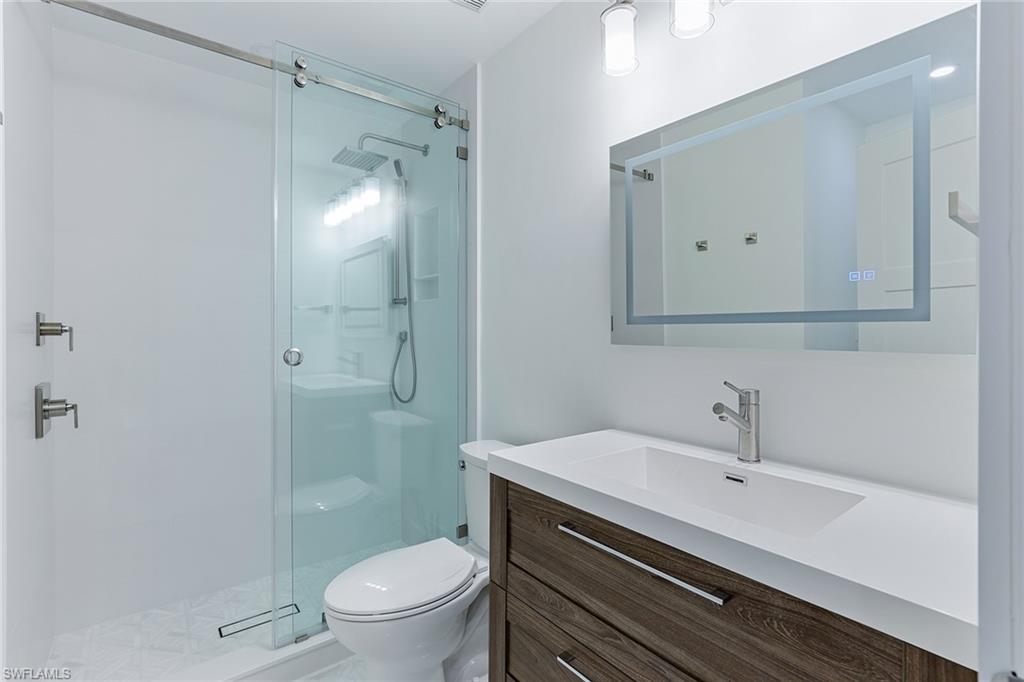 116 Fountain Circle Naples, FL 34119 - Photo 15 of 24 a bathroom with a sink a toilet and shower
