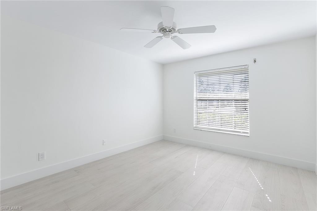116 Fountain Circle Naples, FL 34119 - Photo 16 of 24 an empty room with a window and a fan