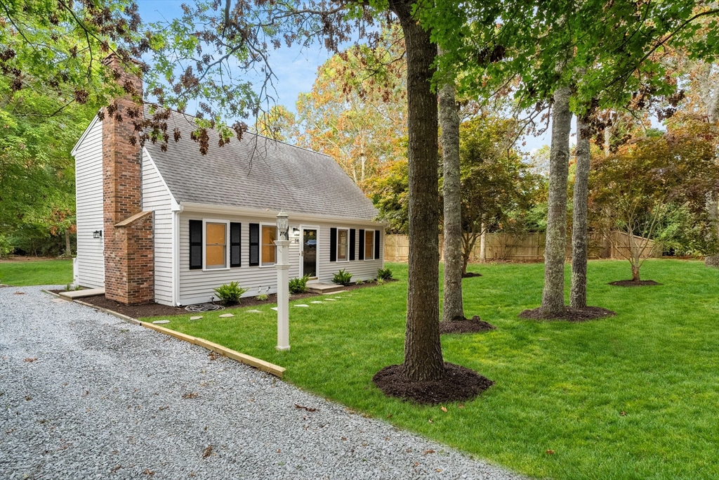 34 Saddleback Road Mashpee, MA 02649 - Photo 2 of 24 a front view of a house with a yard and trees