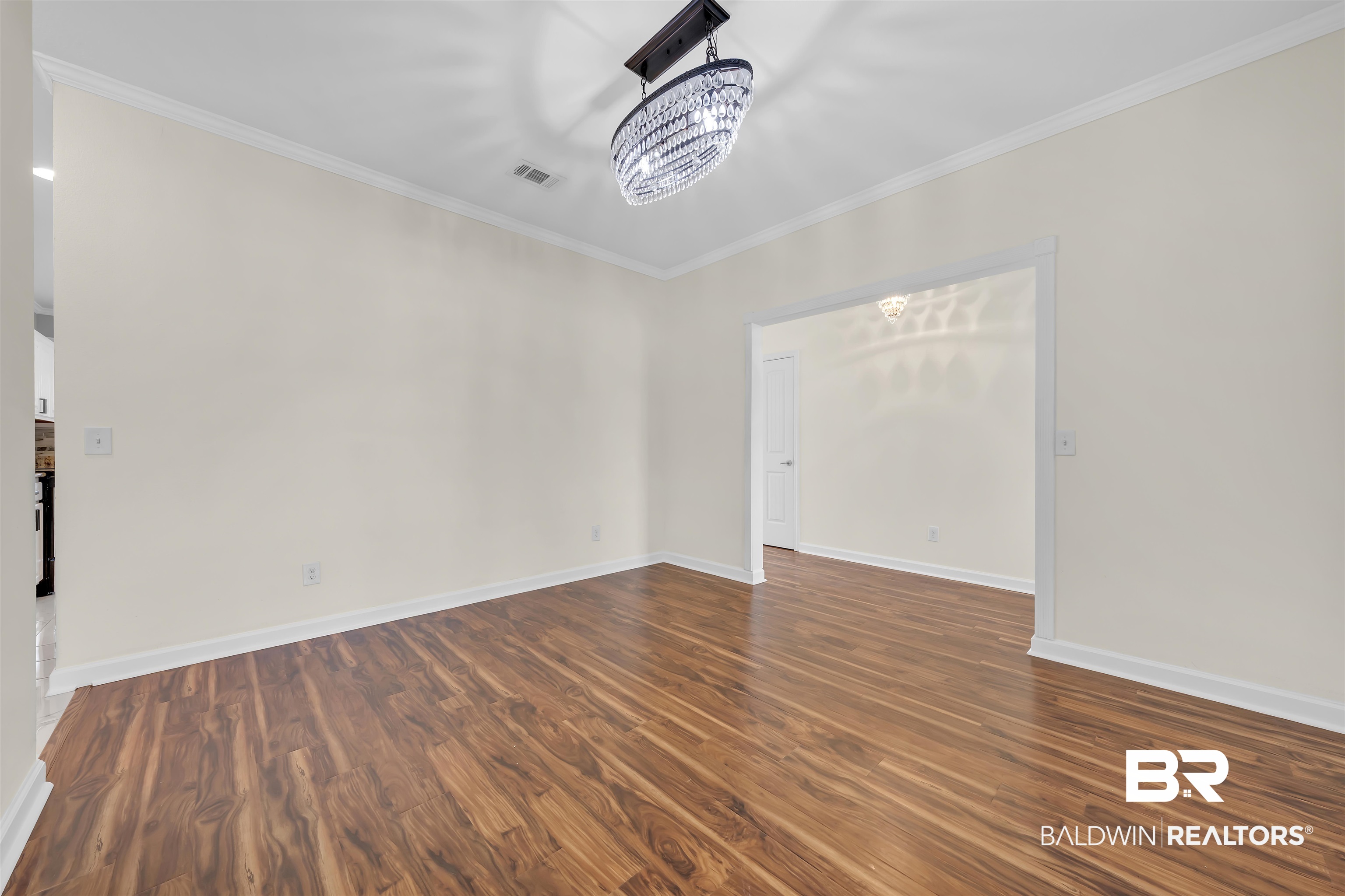 10147 Lyttleton Loop Lillian, AL 36549 - Photo 10 of 29 Spacious interior room featuring wood-finish flooring, crisp white baseboards, and crown molding