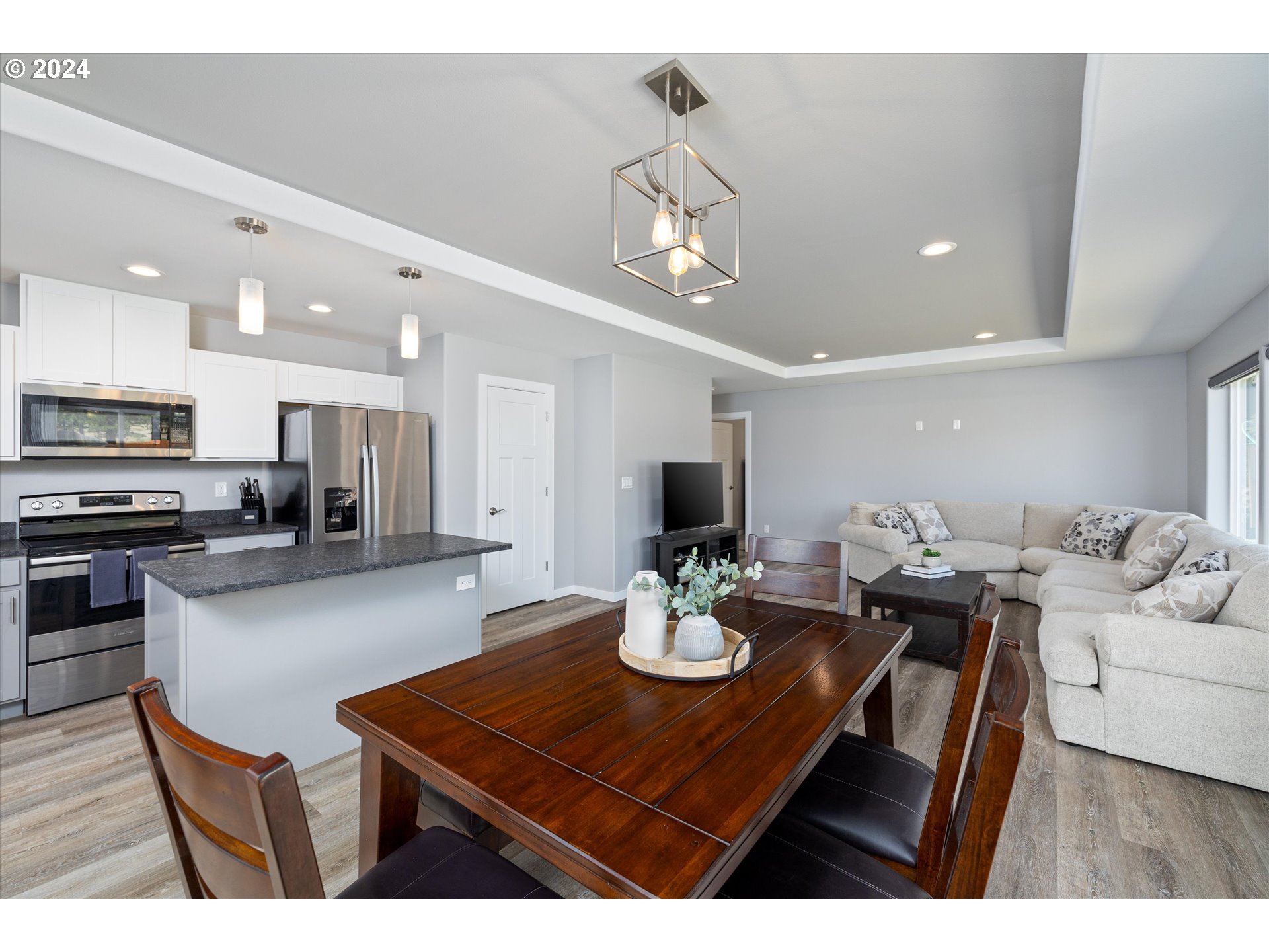 1489 Elberta Street West The Dalles, OR 97058 - Photo 11 of 29 a kitchen with a dining table wooden floor and stainless steel appliances