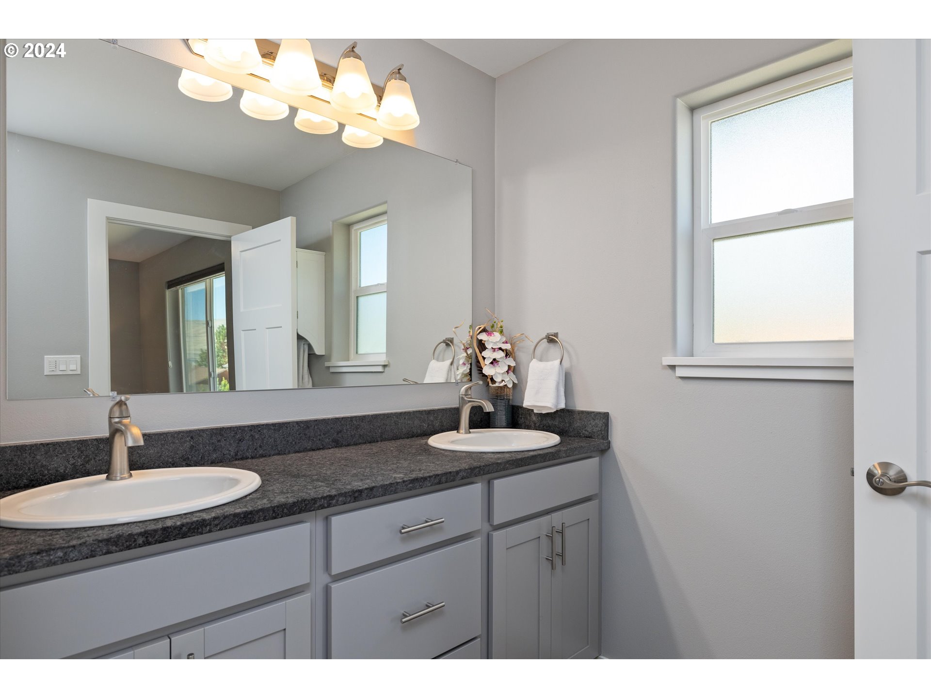 1489 Elberta Street West The Dalles, OR 97058 - Photo 15 of 29 a bathroom with a double vanity sink and a mirror