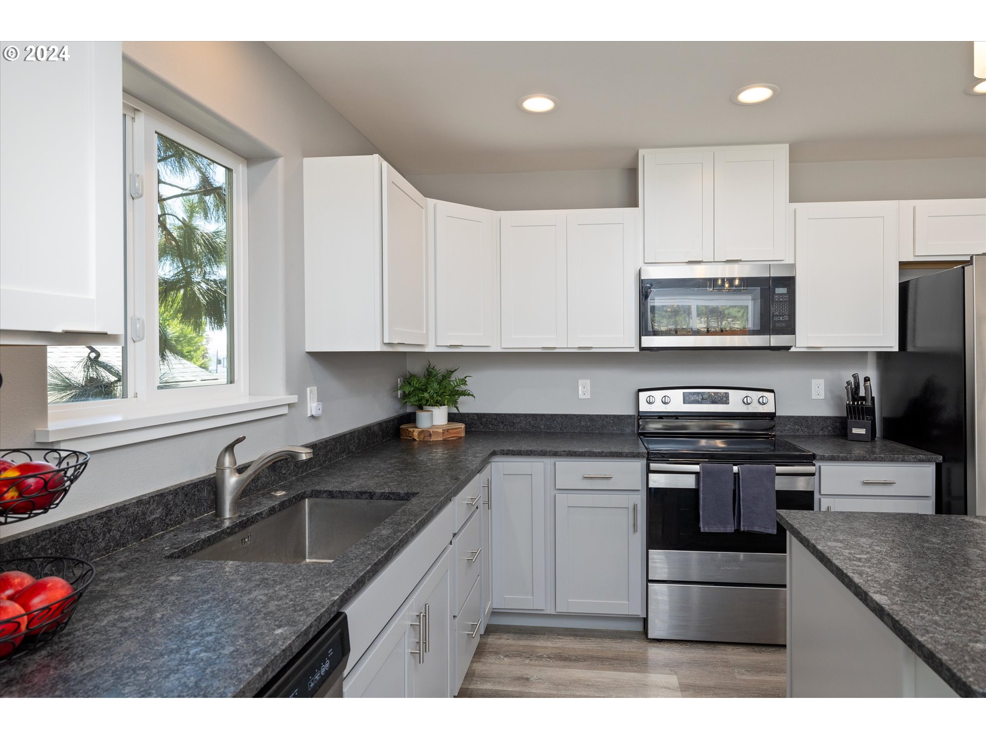 1489 Elberta Street West The Dalles, OR 97058 - Photo 8 of 29 a kitchen with stainless steel appliances granite countertop a sink a stove top oven a counter space and cabinets