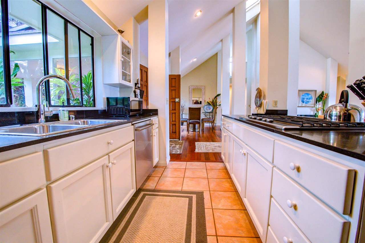 311 Door Of Faith Road Haiku, HI 96708 - Photo 15 of 30 a large kitchen with stainless steel appliances a sink and cabinets