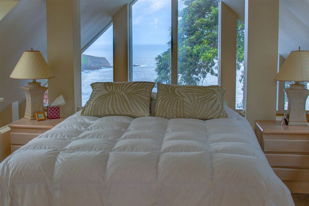 311 Door Of Faith Road Haiku, HI 96708 - Photo 23 of 30 a bedroom with a large bed and a lamp on table