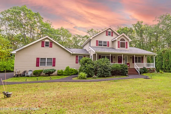 a front view of house with yard and outdoor seating