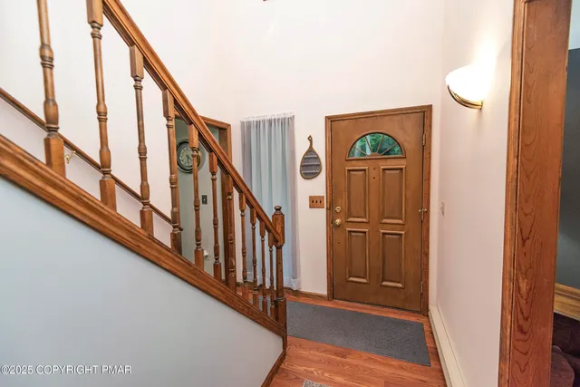 a large kitchen with kitchen island a sink a stove a refrigerator and a dining table with wooden floor