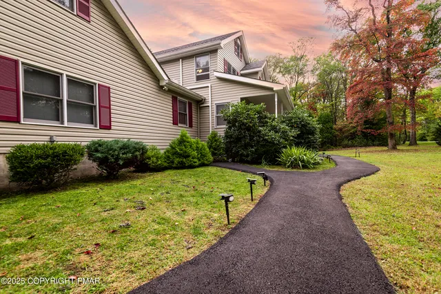 a front view of a house with a yard and trees