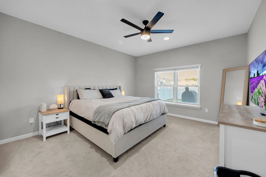 161 Goldcrest Way St. Augustine, FL 32092 - Photo 13 of 52 a spacious bedroom with a bed and a chandelier