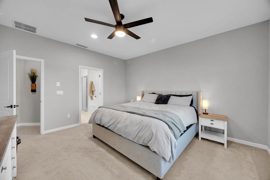 161 Goldcrest Way St. Augustine, FL 32092 - Photo 16 of 52 a bedroom with a bed and a chandelier