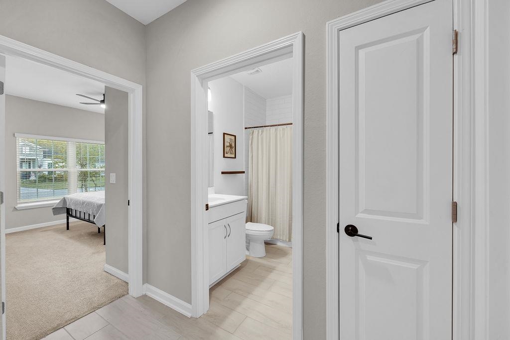 161 Goldcrest Way St. Augustine, FL 32092 - Photo 18 of 52 Bathroom featuring a shower with curtain, vanity, ensuite bathroom, light colored carpet, and ceiling fan