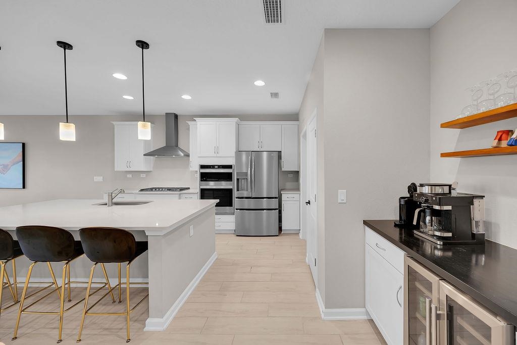 161 Goldcrest Way St. Augustine, FL 32092 - Photo 9 of 52 a kitchen with stainless steel appliances kitchen island a sink a stove a refrigerator and chairs