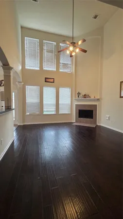 a view of a livingroom with wooden floor and a kitchen space