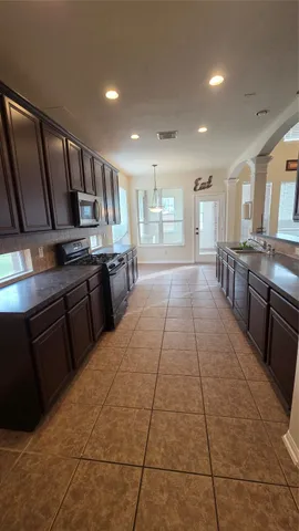 a large kitchen with stainless steel appliances granite countertop a stove a sink dishwasher and cabinets