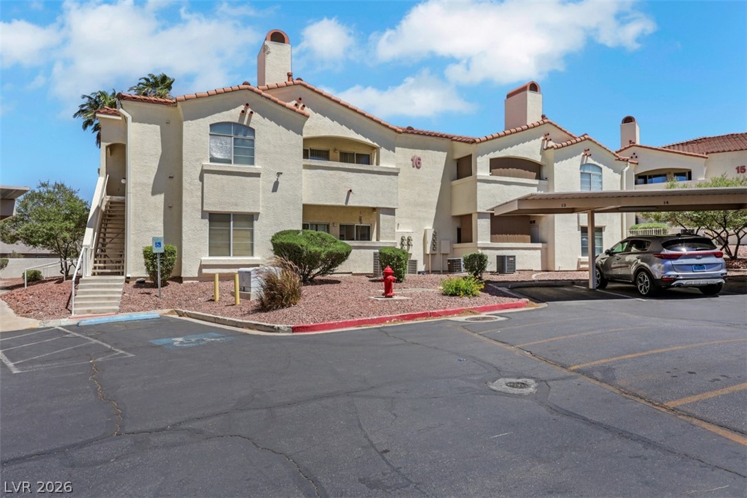 698 South Racetrack Road, Unit 1614 Henderson, NV 89015 - Photo 9 of 35 A terracotta-tiled roof crowns this multi-level residential structure with accessible outdoor stairs and covered parking.
