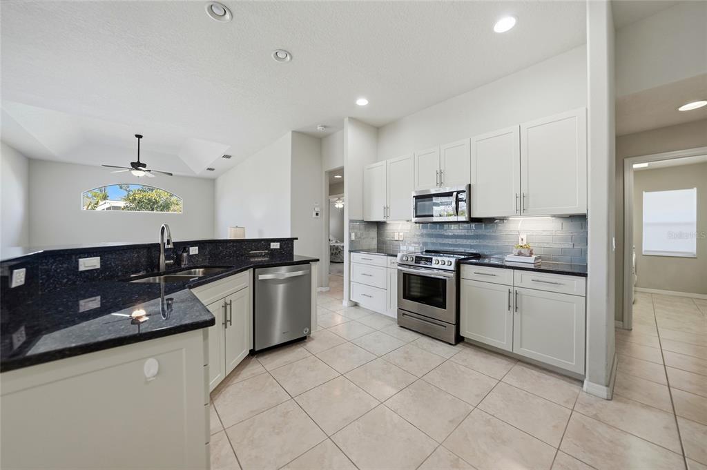 5455 Graves Terrace Port Charlotte, FL 33981 - Photo 13 of 54 a large kitchen with stainless steel appliances granite countertop a sink and stove top oven