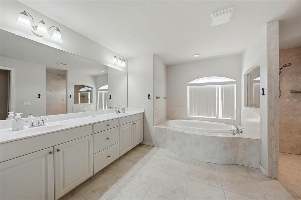 5455 Graves Terrace Port Charlotte, FL 33981 - Photo 23 of 54 a spacious bathroom with a double vanity sink a mirror and a bathtub