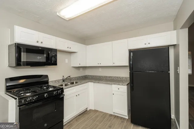 a kitchen with a sink stove and microwave