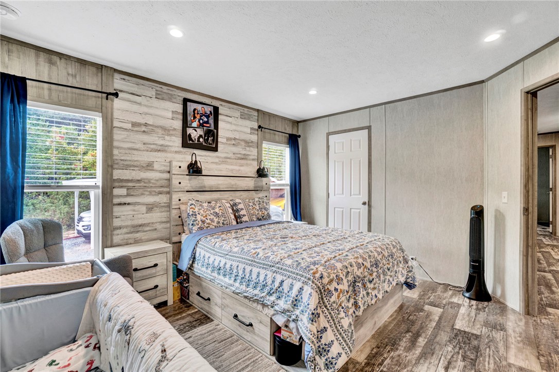 2655 State Rd S-4-108 Anderson, SC 29624 - Photo 13 of 37 Recessed lighting illuminates this bedroom finished with wood-patterned flooring and paneled walls.