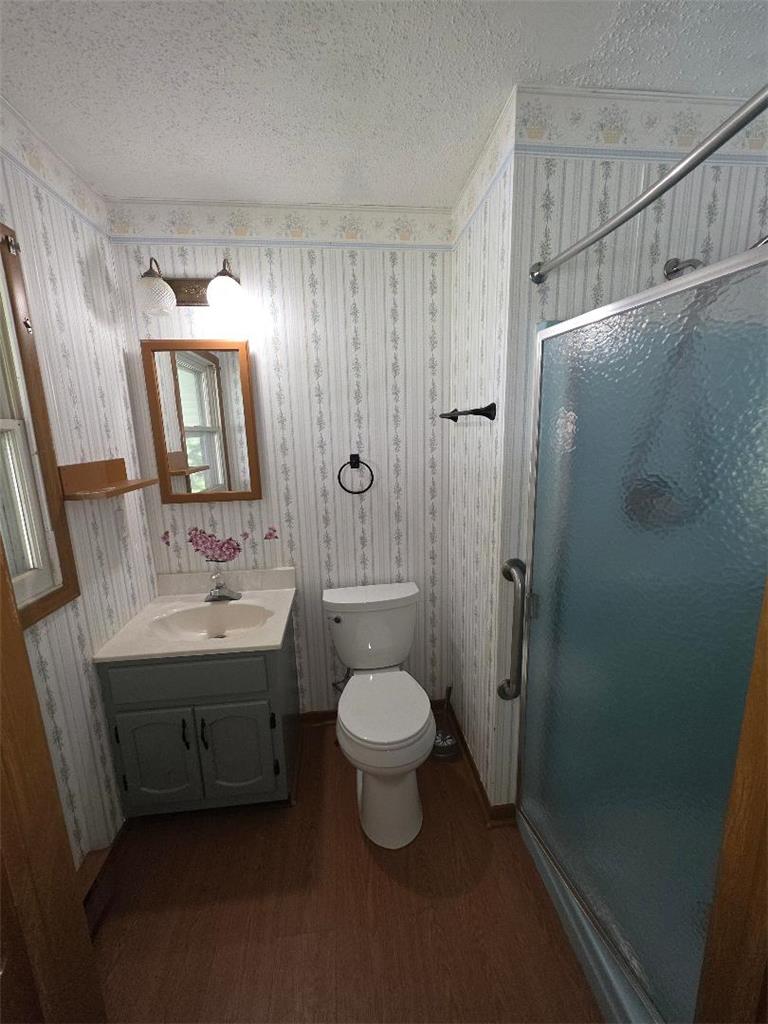 1495 Koch Road Kunkletown, PA 18058 - Photo 7 of 10 Functional bathroom layout features a wood-framed mirror alongside patterned wallpaper and durable laminate flooring.