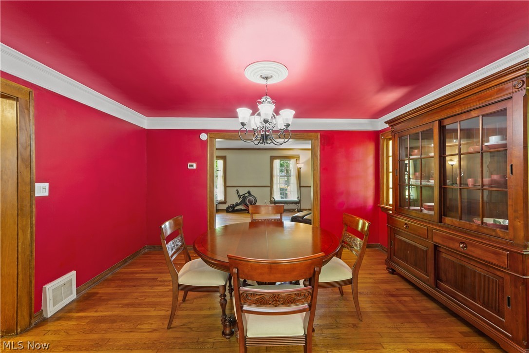 1237 Yellowstone Road Cleveland, OH 44121 - Photo 16 of 48 Dining room featuring ornamental molding, hardwood / wood-style flooring, and a chandelier