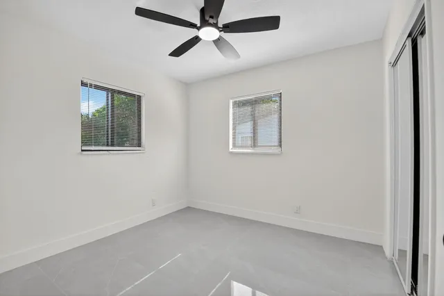 an empty room with a window and a fan
