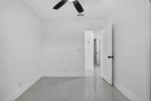 an empty room with closet and windows