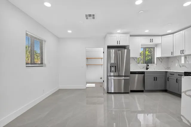a kitchen with a refrigerator and a stove top oven