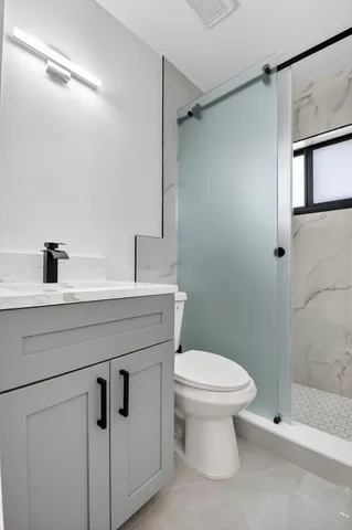 a bathroom with a granite countertop sink toilet and shower