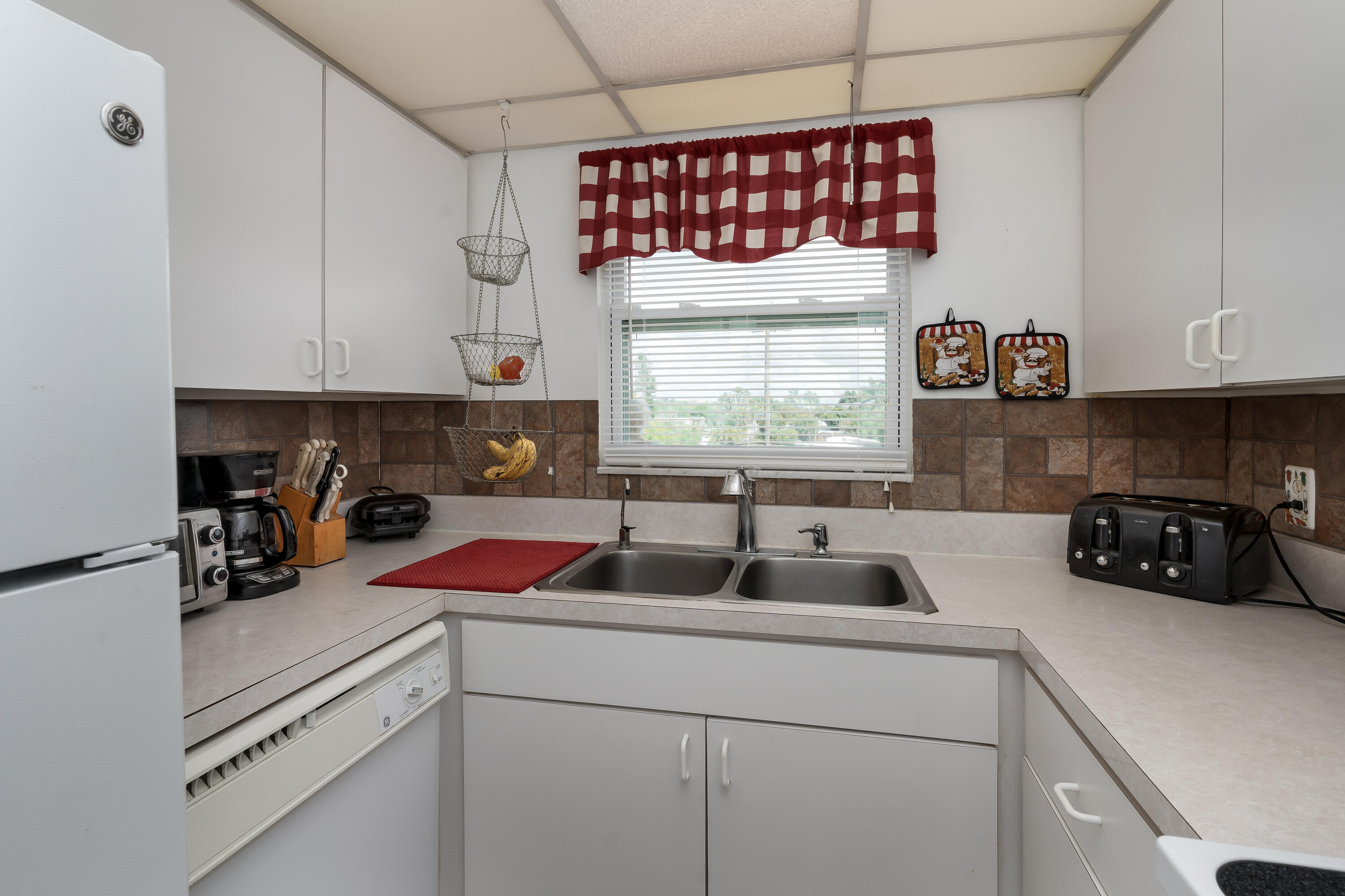 1010 Manatee Road, Unit B 305 Naples, FL 34114 - Photo 9 of 23 a kitchen with a sink cabinets and window