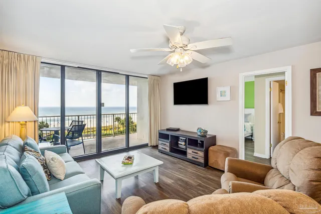 a living room with furniture a flat screen tv and a large window
