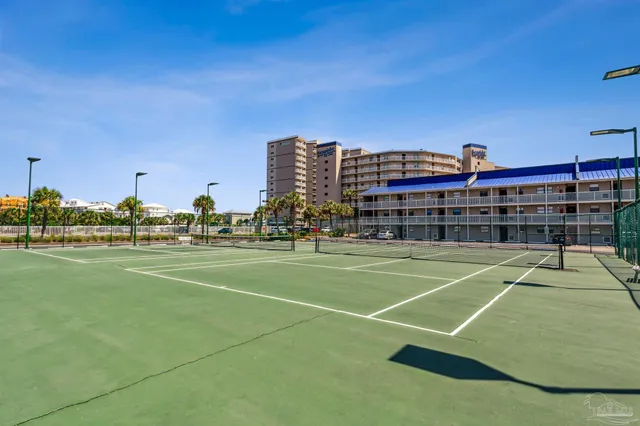 a patio with table and chairs and potted plants