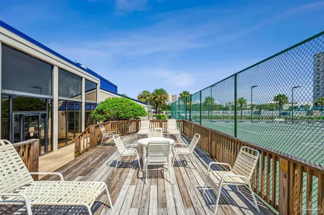 a view of a balcony with floor to ceiling windows and wooden fence