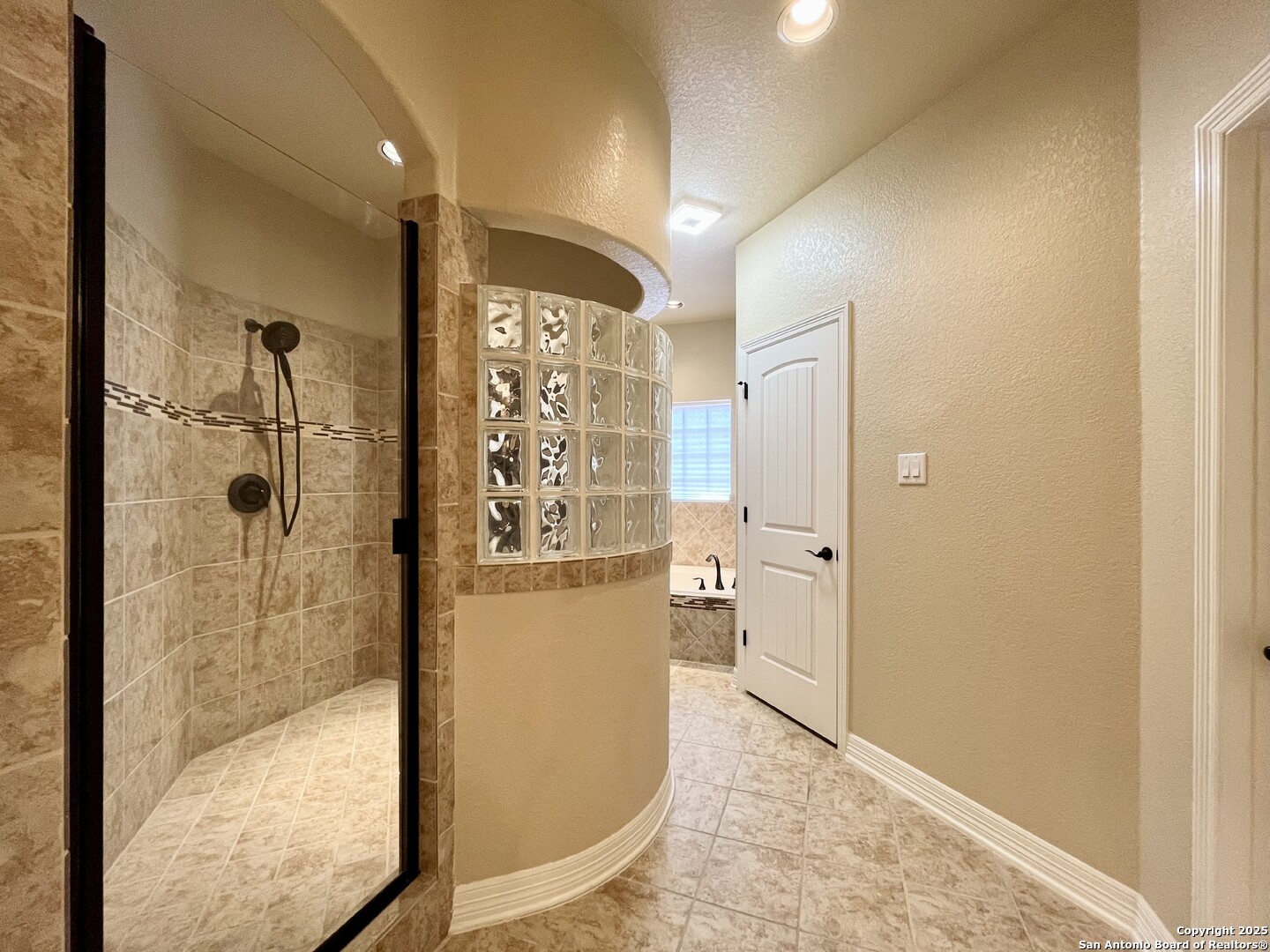8123 Poconos Run San Antonio, TX 78255 - Photo 23 of 47 a bathroom with a glass shower door and a window