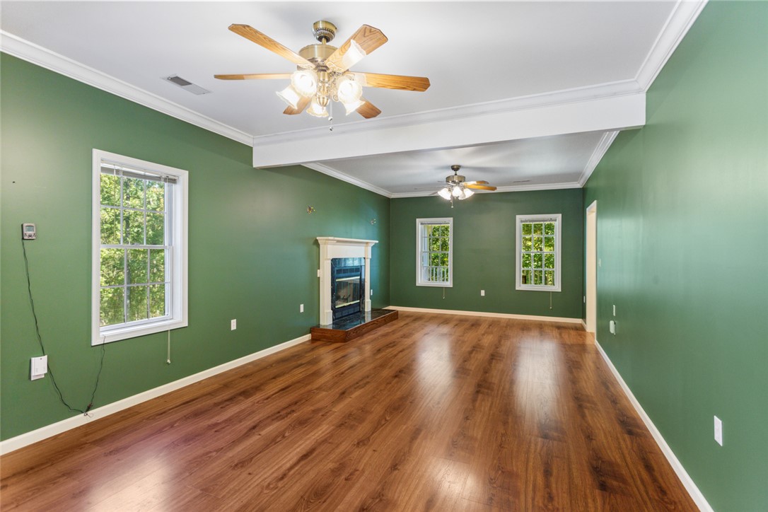 621 Burns Mill Road West Union, SC 29696 - Photo 5 of 45 A well-lit living area features rich hardwood flooring and a classic fireplace, perfect for cozy gatherings.