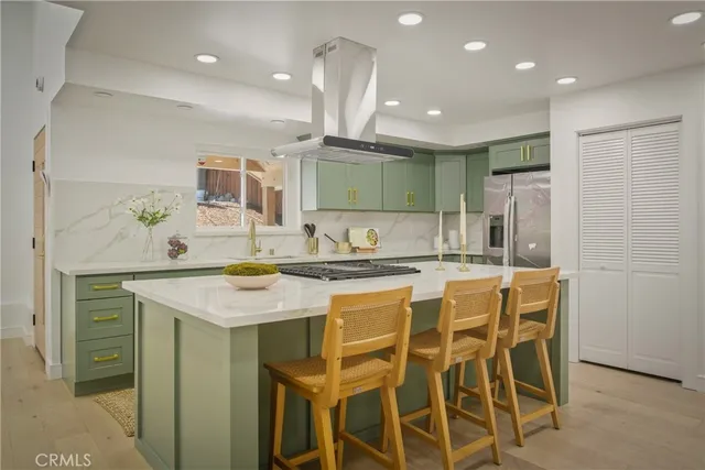 a kitchen with kitchen island granite countertop a sink and a refrigerator