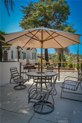 a view of a patio with table and chairs under an umbrella