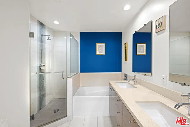 a bathroom with a bathtub shower sink vanity and mirror