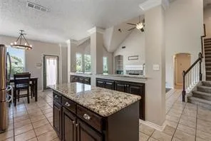 a kitchen with granite countertop a stove and a dining table